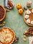 Variety of traditional Thanksgiving pies on green background with copy space