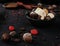 A variety of truffles in a black clay pile and chocolate spoon w