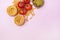 Variety of Types and Shapes of Dry Pasta Tagliatelle Fusilli Raw Tomatoes Bowl of Pesto Top View Pink Background Copy Space