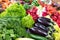 A variety of vegetables, black eggplants, juicy lettuce, dill, parsley, radish, zucchini are on the market counter