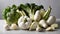 A variety of vegetables, including broccoli, cauliflower, and garlic, are displayed on a table