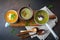 Variety of vegetarian soups cream of carrots, broccoli and cauliflower on a dark concrete background. Selective focus. Top view.