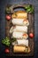 Variety of vegetarian tasty wraps on rustic cutting board on dark background, top view. Healthy lunch