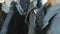 A variety of women`s denim jackets hanging on a hanger. Woman chooses her clothes in the store. Hands close up