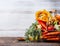 Various autumn seasonal organic vegetables ingredients: pumpkin,carrot,paprika,tomatoes,ginger in basket on wooden kitchen desk ta