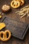 Various beer snacks - chips, pretzels and nuts on wooden board.