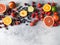 Various berries and fruits on a gray background. Strawberries, cherries, orange, peach, blueberries, lime, grapefruit.