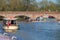 various boats on river Avon in Stratford with people walking across brick wall