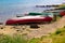 Various canoes chained up on a sandy shore