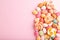 Various caramel candies on pink background. copy space, top view