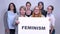 Various caucasian group of girls standing with sing feminism close to each other smiling inside