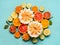 Various citrus fruits on light blue background, top view. Composing with half of orange fruits, lemon, grapefruit, mandarin, lime