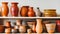 Various clay vases and ceramic plates placed on shelf against white background near cup, Generative AI