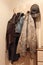 Various clothes hanging on coat rack.