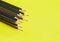 Various color of sharpened wooden pencils on yellow background, isolated with copy space or space for text