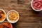 Various colorful hummus with addition of baked beetroots, grilled pepper and pumpkin on a wooden background