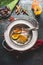 Various colorful spices in spoons on vintage plate on rustic background, top view. Asian, oriental or indian cuisine