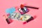 Various cosmetics accessories and banknote of 100 dollars on pink background