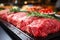 Various cuts of fresh raw red meat in the supermarket, beef, pork, assorted meat steaks on a baking sheet before cooking