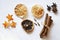 Various dry ingredients: cinnamon, dry lemon slices, clove seasoning, anise stars on a white background. Photo image