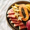 Various exotic tropical fruits on a metal tray in bed, concept of tropical healthy breakfast in bed