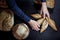 Various French breads, such as baguette, petits pains & loafs of sourdough, pain de campagne, some being held by female hands
