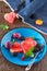 Various fresh fruits and berries on a plate on a brown stone or slate background - watermelon, blackberries, plums and grapes