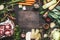 Various Fresh organic ingredients for Broth or soup cooking with vegetables and meat on dark wooden background, top view