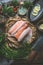 Various of fresh raw fish fillets on kitchen table background with herbs, spices and lemon slices. Colorful raw fish selection.