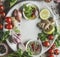 Various fresh seasoning for fermentation or preserving: onion, ginger, garlic, herbs, salt, lemon and chili pepper on white plate