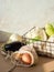 Various fresh vegetables in cloth reusable bags and metal black basket in the sun on kitchen table