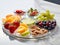 various frozen fruits in five compartment plate on white marble table. served with elegance