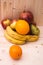 Various fruits apples, bananas, oranges, pomegranates on natural wooden background
