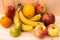 Various fruits apples, bananas, oranges, pomegranates on natural wooden background