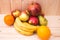 Various fruits apples, bananas, oranges, pomegranates on natural wooden background