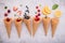 Various of fruits  in cones blueberry ,strawberry ,raspberries and strawberry setup on white stone background . Summer and Sweet