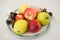 Various fruits on plate. Fresh and colored apples, grapes and nectarines on table