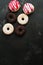 Various glazed donuts on a dark stone background. Top view, copy space