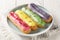 Various glazed sweet eclairs with with berry tastes closeup on plate. Horizontal