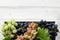 Various grapes with leaves in white wooden tray