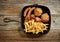 Various grilled meat and fried potatoes on cast iron pan