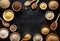 Various groats, cereals. Different types of groats in bowls and on a spoons on a black background, top view.