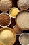 Various groats, cereals. Different types of groats in bowls on a wooden background, top view, close up.