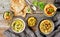 Various hummus spreads on wooden table