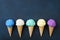 Various ice cream cones on black table flat lay