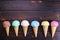 Various ice cream cones on wooden table, flat lay