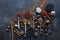 Various indian spices in wooden spoons and metal bowls and nuts on dark stone table. Colorful spices, top view.