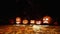 Various Jack-o-lantern pumpkins in night forest