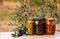 Various jars with olive oil and plates with olives under the olive tree