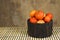 Various juicy and tasty tomatoes in a bowl on the table isolated on blurred background